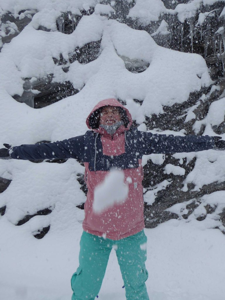 Tina in de sneeuw met roze skijas en appelblauwzeegroene skibroek