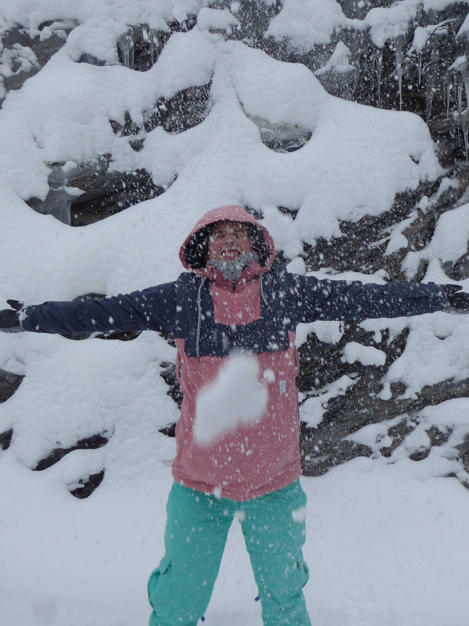 Tina in de sneeuw met roze skijas en appelblauwzeegroene skibroek